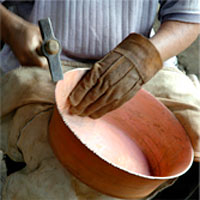 Working on a copper bowl.